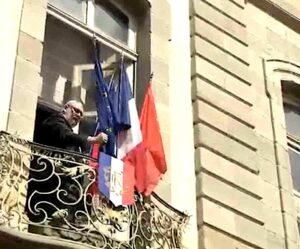Christophe Barthès retirant le drapeau européen de la façade de l'hôtel de ville de Carcassonne le 30 mars 2026