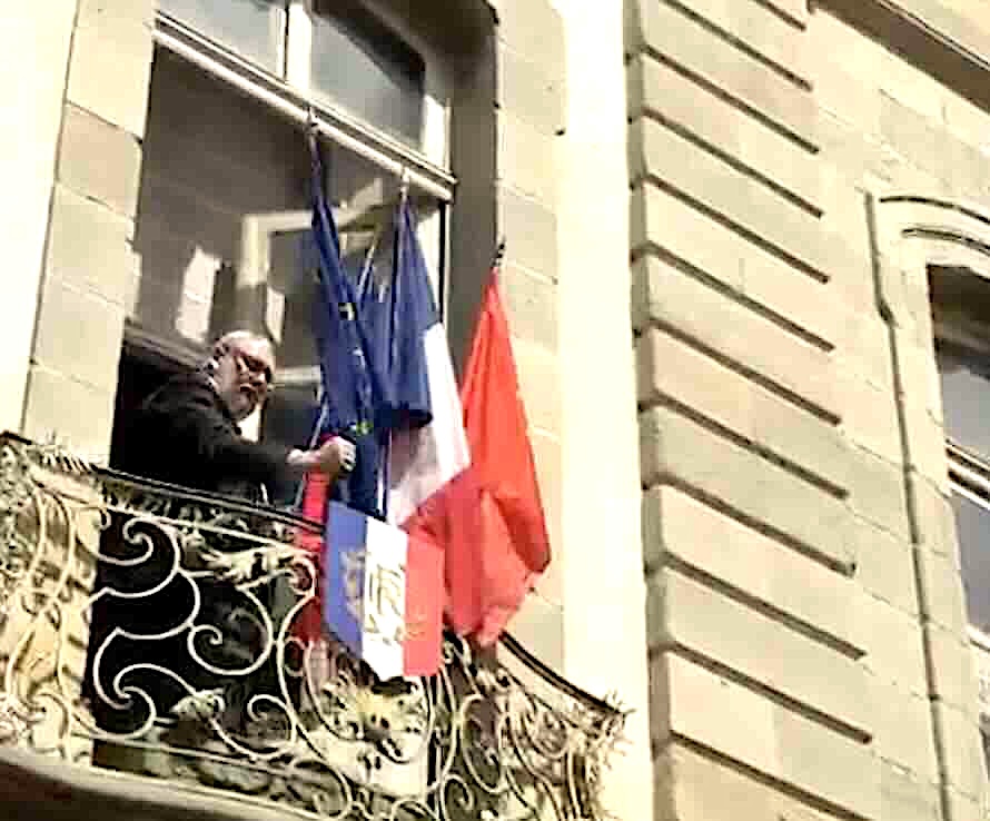 Christophe Barthès retirant le drapeau européen de la façade de l'hôtel de ville de Carcassonne le 30 mars 2026